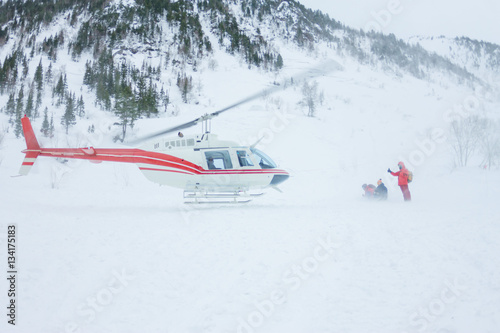 The helicopter landed people in the mountains in winter, raising