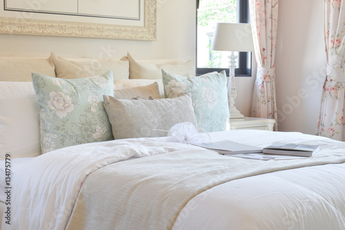 vintage bedroom interior with flower pillows and decorative table lamp