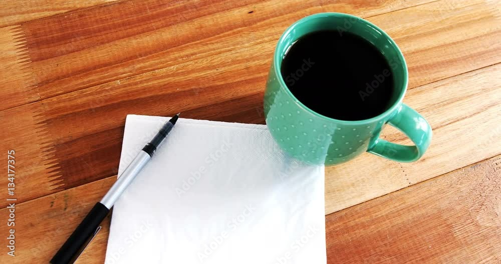 Close-up of coffee mug with blank paper and pen Close-up of coffee mug with blank paper and pen