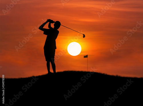 silhouette golfer hit golf ball toward the hole at sunset