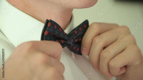 The man straightens his tie. close up.
