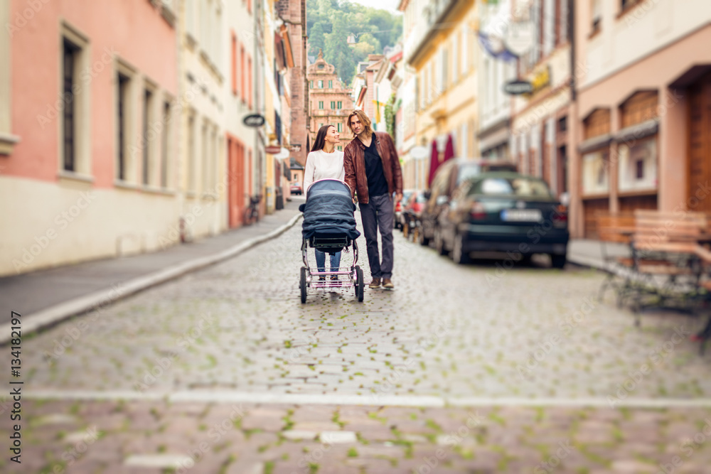 Fototapeta premium Young Parents With Baby Stroller In The City