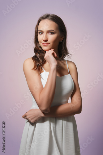 Attractive girl in summer white dress with long curly hair and n