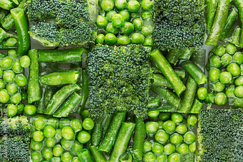 Obraz na płótnie Fresh frozen green peas, french bean, broccoli with hoarfrost closeup as decorative chess background