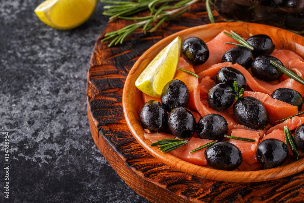 Salmon with olives and lime on a wooden board. Salmon with olives and lime on a wooden board.