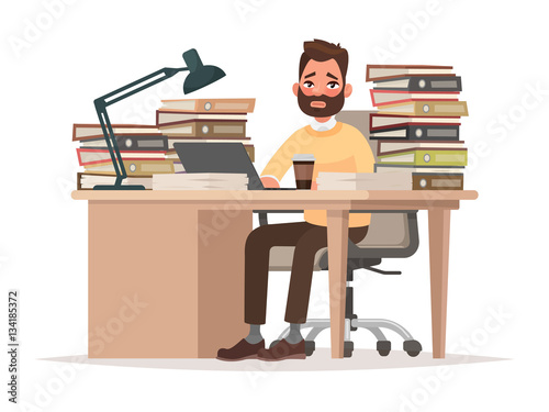 Deadlines at work. Tired office worker man at his desk with a lo
