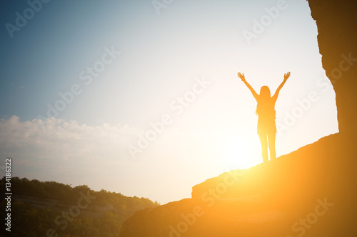 Girl against sun on mountain