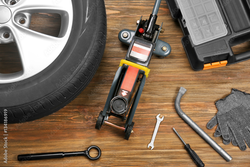 Car wheel with tools on wooden background Car wheel with tools on wooden background