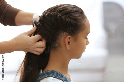 Woman doing hair of her dau...