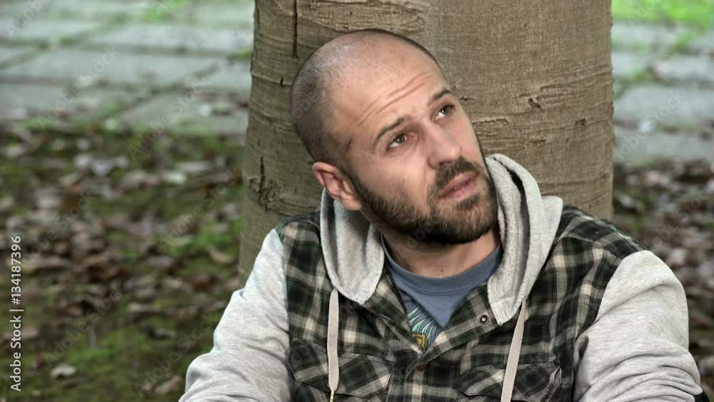 desperate and frustrated man reflects sitting under a tree desperate and frustrated man reflects sitting under a tree