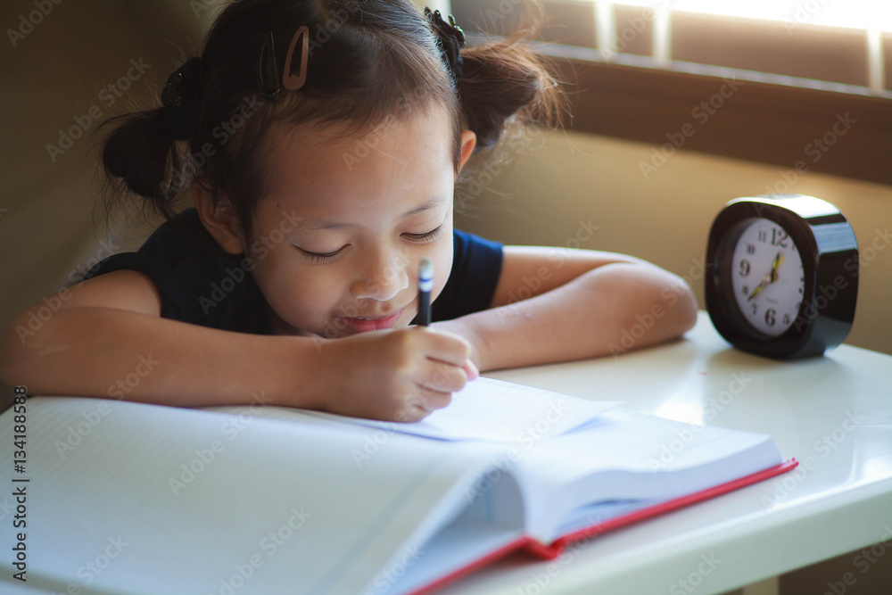 Child girl writing on the wood table with smile.Selective Focus Child girl writing on the wood table with smile.Selective Focus