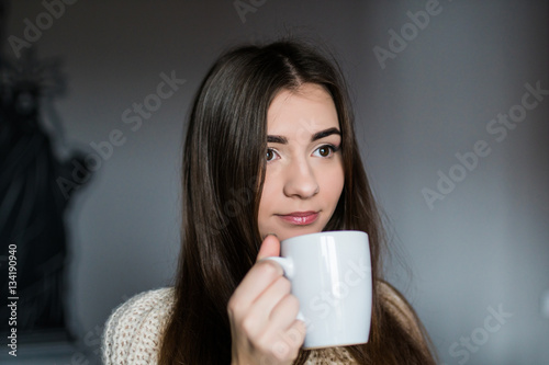 Young attractive woman drinking coffee at home