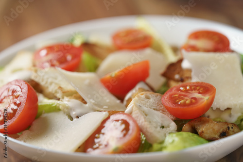 closeup photo of fresh made caesar salad with cherry tomatoes, shallow depth of field