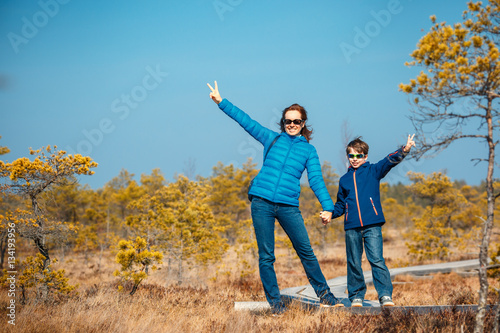 Cute little boy with mother walking on trail in swamp, Kemeri national park, Latvia photo