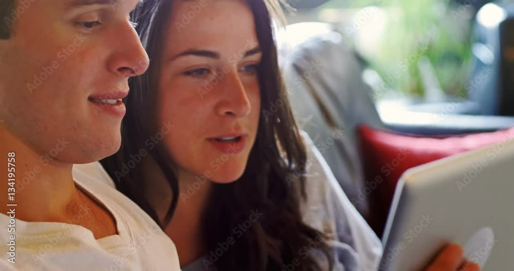 Couple eating popcorn while using digital tablet Couple eating popcorn while using digital tablet