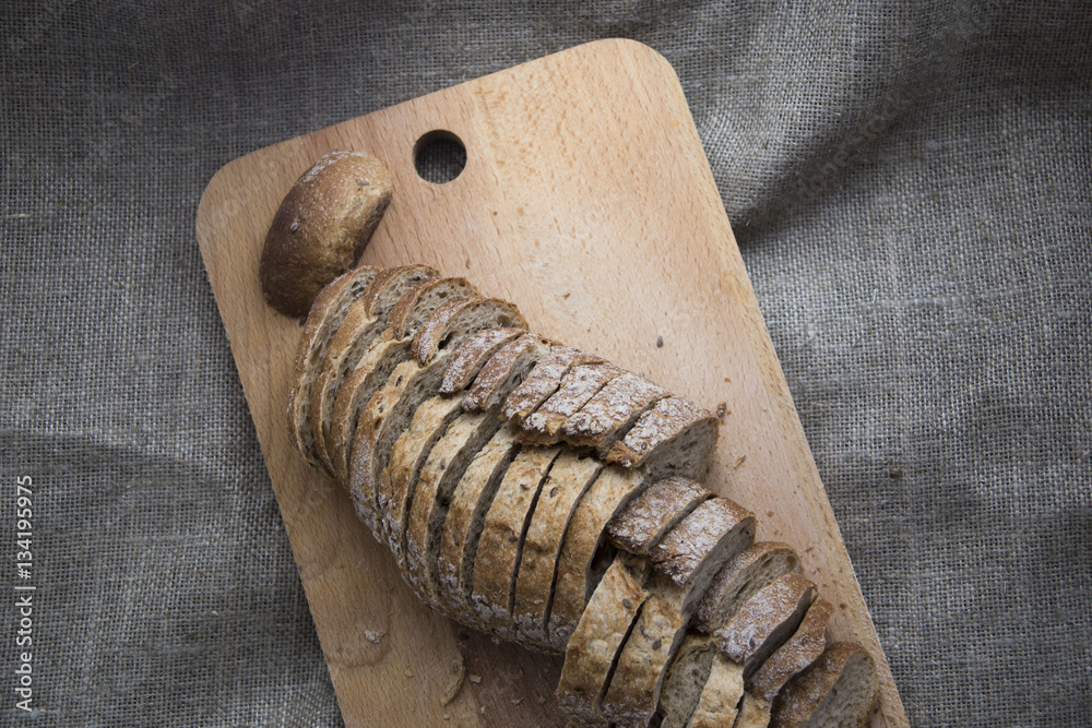 sliced loaf of bread on a board and sacking