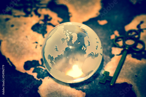 Fototapeta Naklejka Na Ścianę i Meble -  Crystal Globe with Key on Grunge World Map