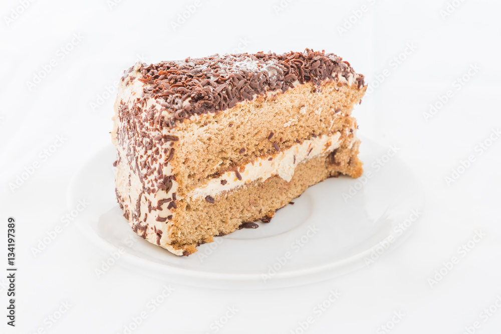 Chocolate cake slice with curl on white dish Chocolate cake slice with curl on white dish