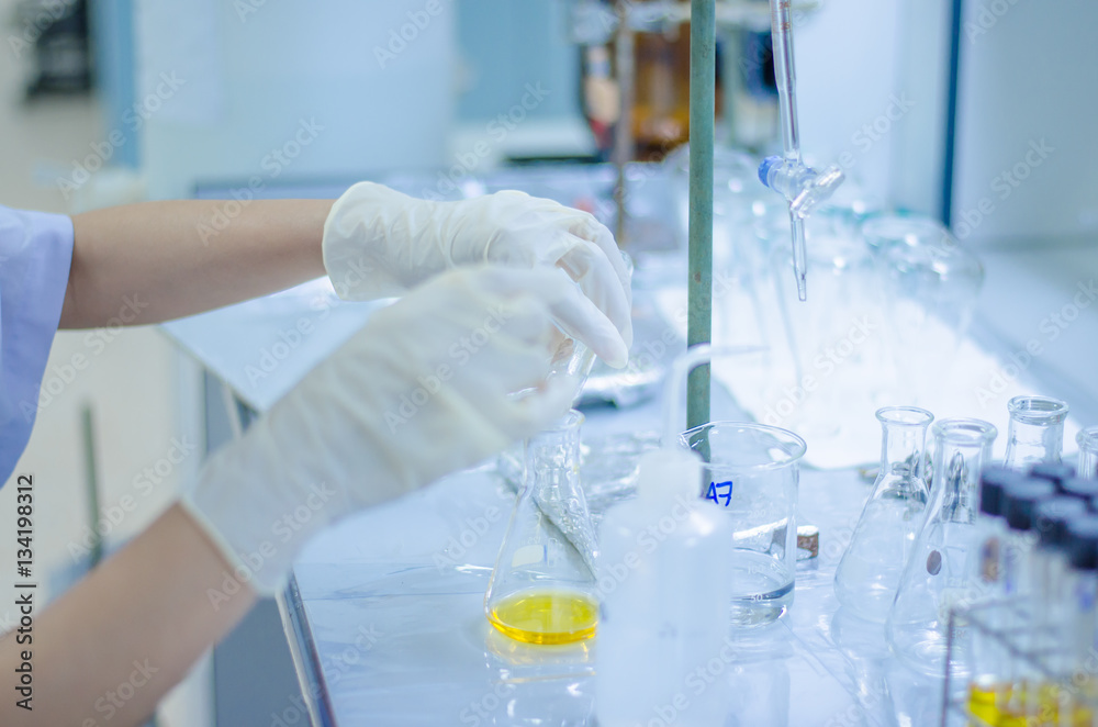 Foto de Scientist hand titration at laboratory, titrate chemical