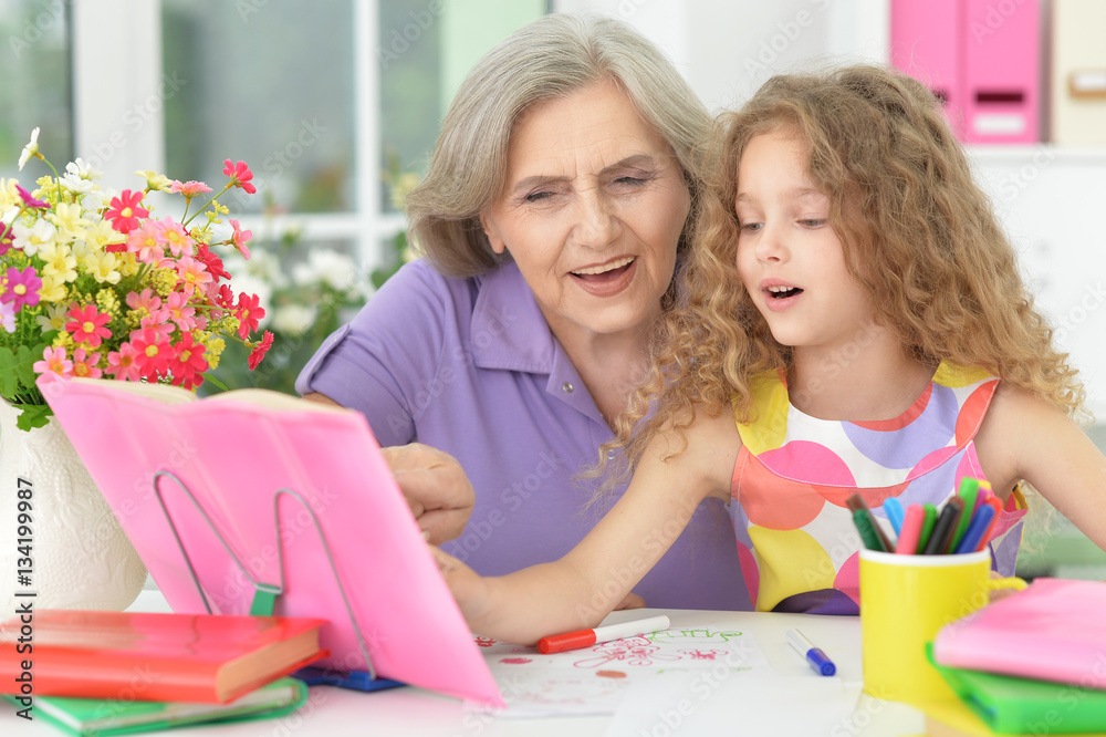 grandmother helping her granddaughter doing homework grandmother helping her granddaughter doing homework
