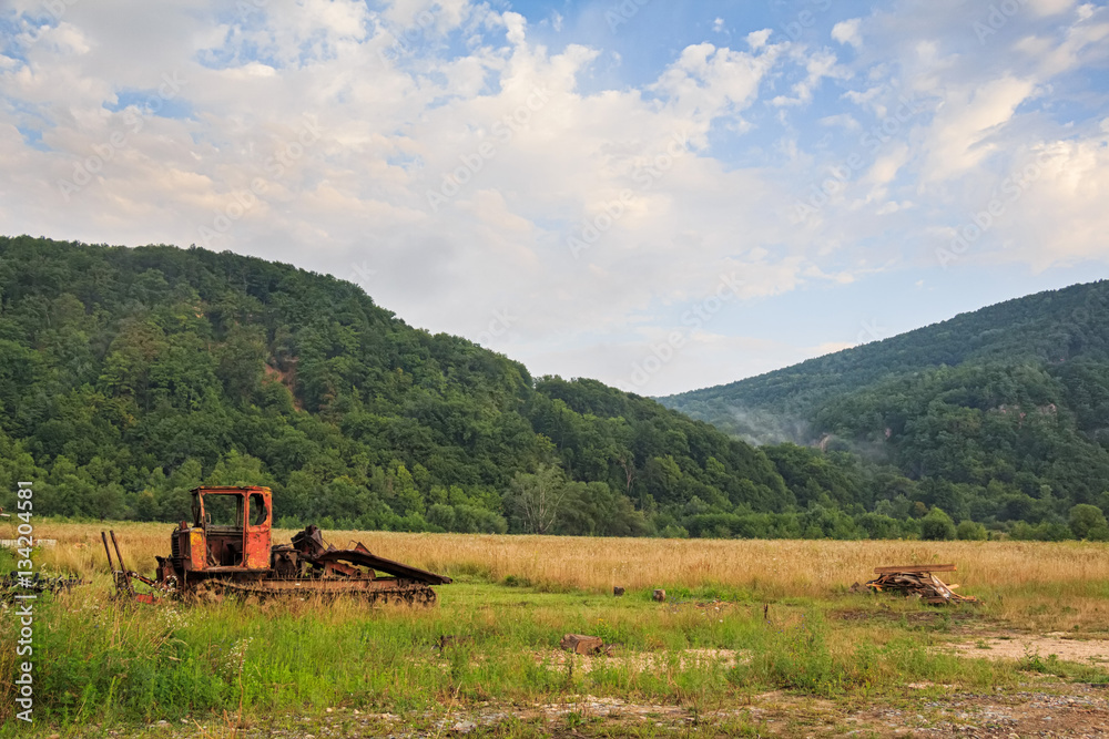 Naklejka premium Bulldozer standing on mountain background