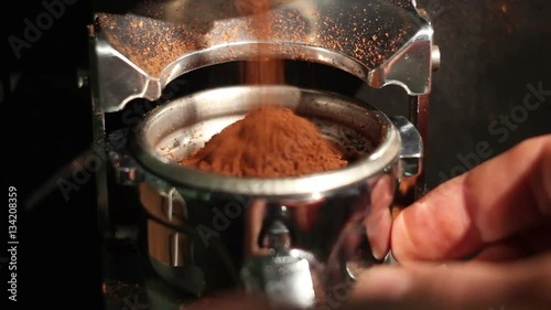 cafe bar coffee grinder pours ground coffee in holder. close up