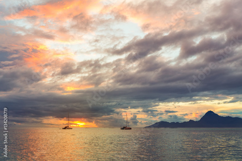 Dramatic sunset and far yachts in the sea