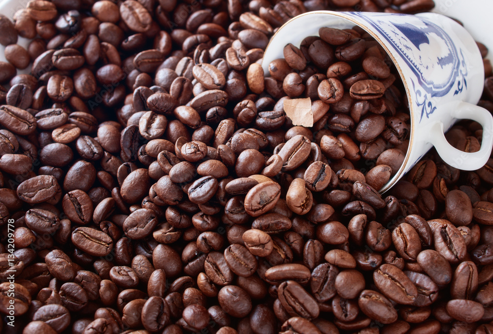 Fototapeta premium Coffee cup from thin porcelain against the background grains.