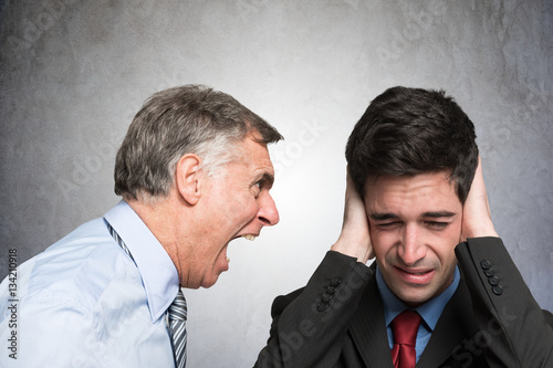 Angry businessman shouting to an employee