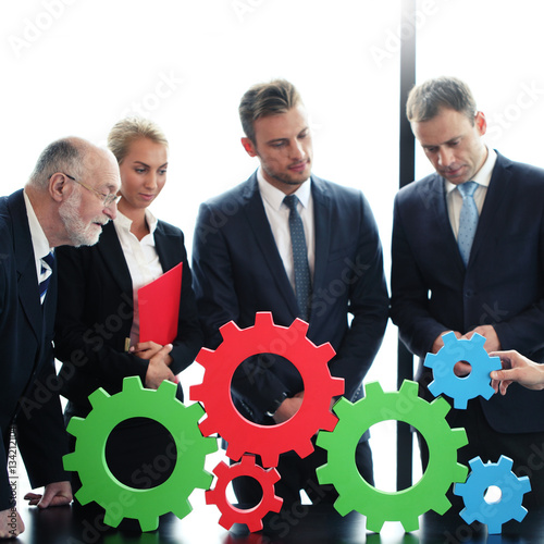 Business people assembling cogs