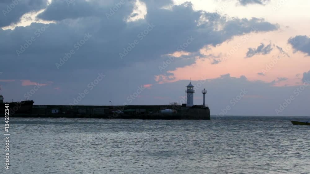 Sunrise in Yalta against a beacon, a view from central embankment
