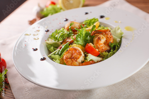 Caesar salad with shrimps and iceberg leaves