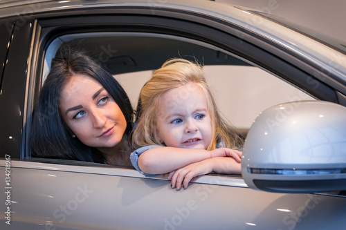 Girl and mom in exhibition hall for car