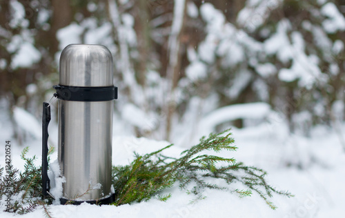 thermos of tea in the snowy forest