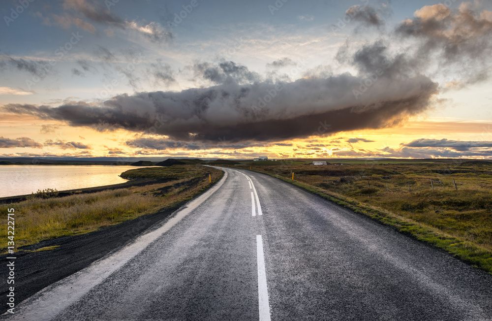 Myvatn, Iceland - dramatic cloud above empty road into sunset