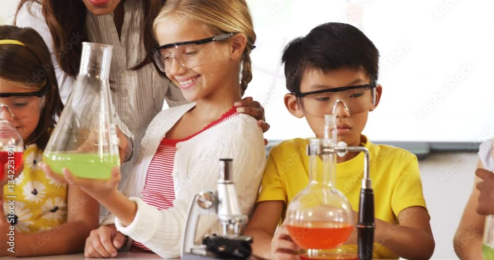 School kids doing a chemical experiment in laboratory