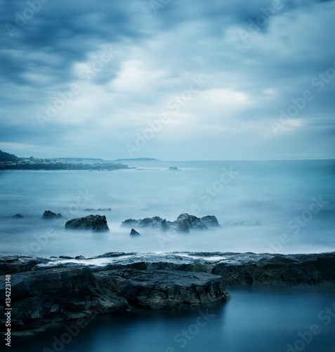 Peaceful Winter Seascape. Sea or Ocean with Dramatic Sky. Long Exposure. Calm Water and Moody Sky. Cold Mysterious Tranquility Concept. Blue Toned Photo with Copyspace. © Maryia Bahutskaya