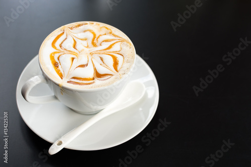 Latte art cup on dark background