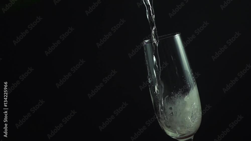 Close up of glass with champagne pouring into it. Slow motion hd video Close up of glass with champagne pouring into it. Slow motion hd video
