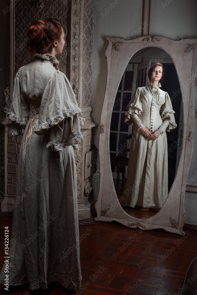 Naklejka premium The woman looks in the mirror, retro image.