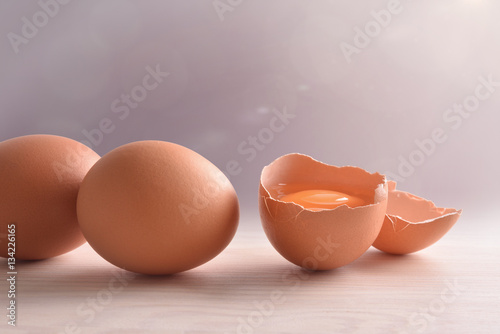 Fresh eggs on wooden bench with gray background and light