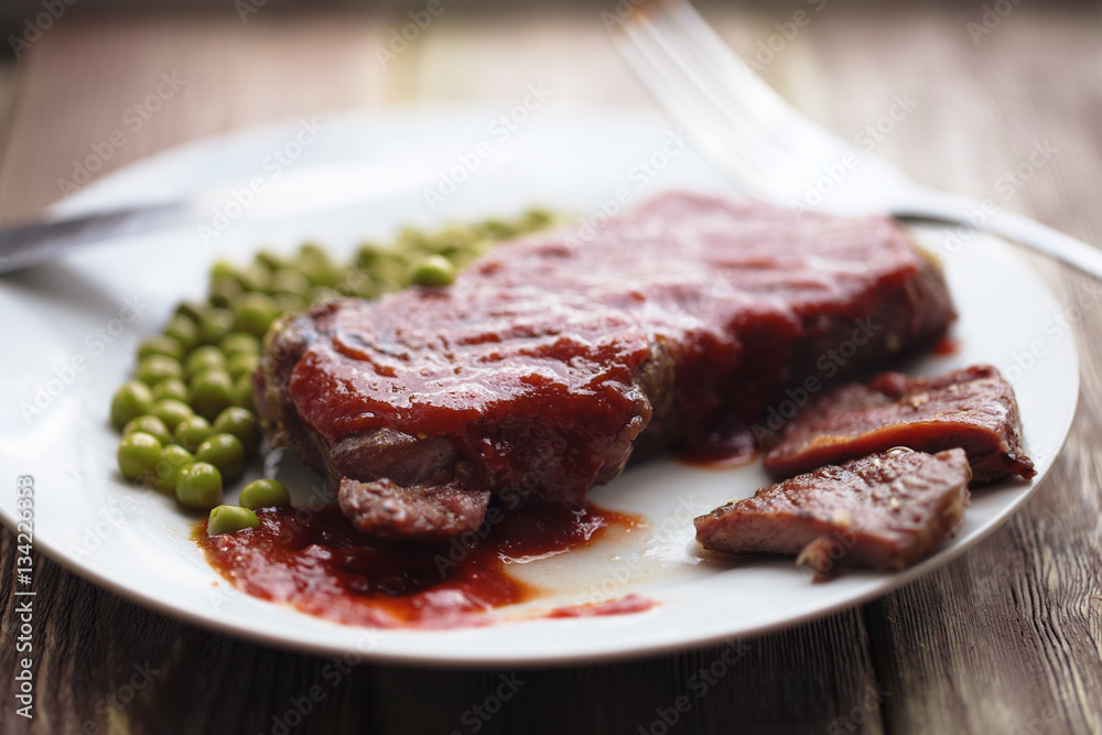 beef steak with tomato sauce and peas