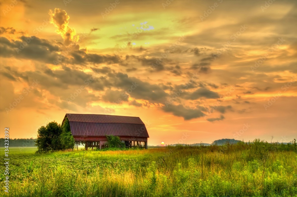 Wooden Barn Sunset. Rural sunset with an abandoned barn surrounded by farm fields. - obrazy, fototapety, plakaty 