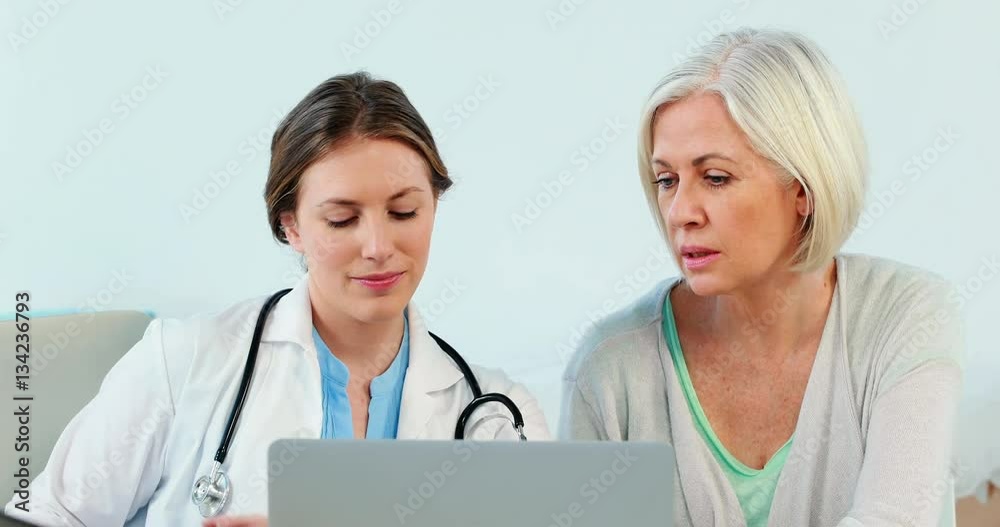 Female doctor interacting over a x-ray report with a patient Female doctor interacting over a x-ray report with a patient