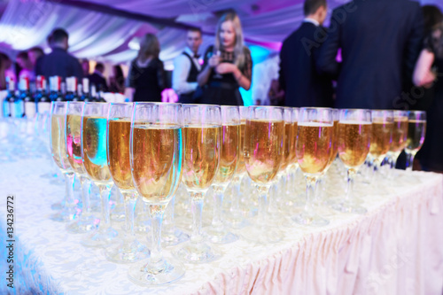 Fotografia glasses with white sparkling wine in row at restaurant event
