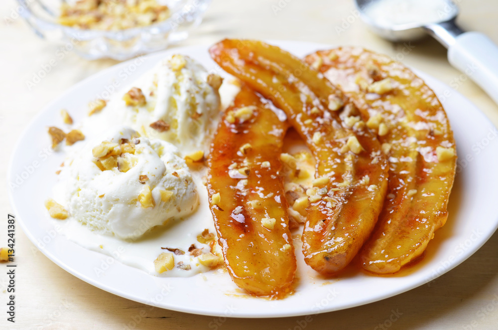 Caramelized Bananas, Ice-cream and Chopped Nuts Dessert on a plate Caramelized Bananas, Ice-cream and Chopped Nuts Dessert on a plate