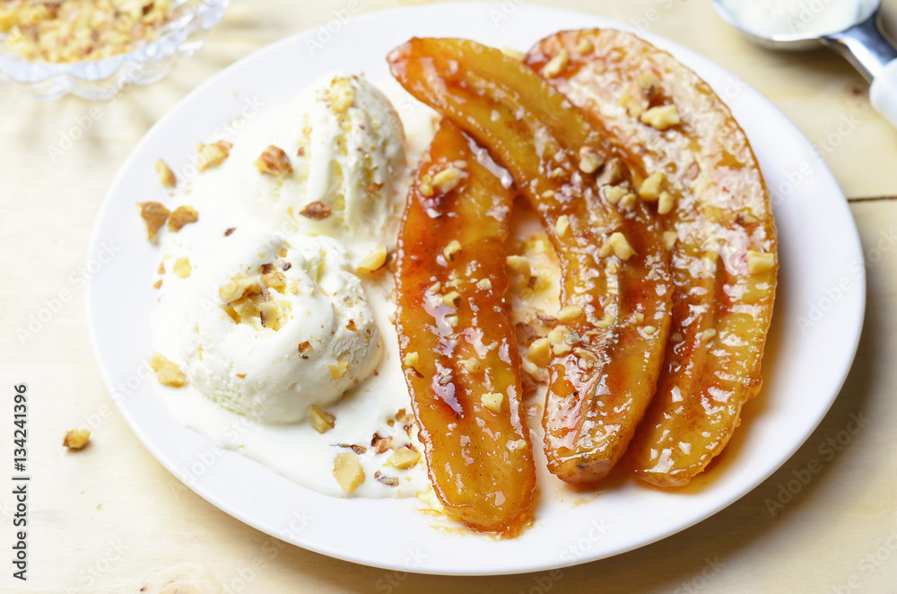 Caramelized Bananas, Ice-cream and Chopped Nuts Dessert on a plate