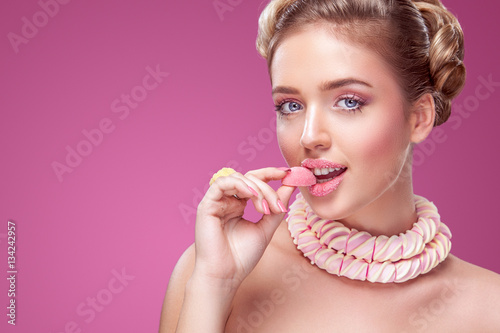 Photos Attractive woman with lollipop in hand on pink background