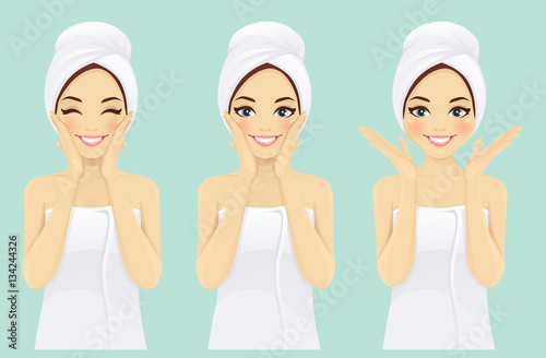 Beautiful young woman in towel with clean fresh skin touch own face