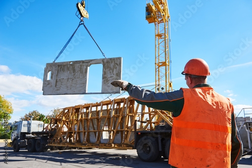 Construction industrial worker operating hoisting process of concrete slab photo